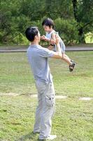 Sud est asiatico giovane Cinese padre figlio genitore bambino giocare rilassare attività all'aperto parco Sorridi amore foto