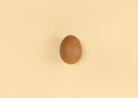 uovo marrone su sfondo beige piatto minimalista laici foto