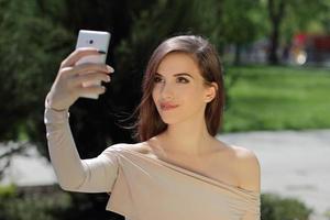 ragazza sorridente che ascolta la musica sul telefono cellulare foto