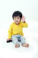 Sud est asiatico giovane ragazzo bambino giocando contento agitando mano a telecamera su bianca sfondo foto