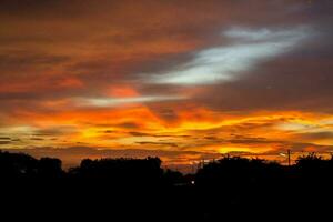 colorato rosso, blu, e giallo cielo nel il sera nel un' rurale la zona nel Tailandia, quando il sole ha impostare, è un' panoramico Visualizza di il calore. piccante, caldo e pauroso foto