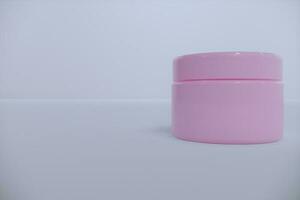 rosa vuoto lucido cosmetico plastica vaso finto su modello su isolato bianca sfondo, cosmetico contenitore per corpo crema, gel, Burro, bagno sale, pelle cura, polvere. 3d illustrazione foto