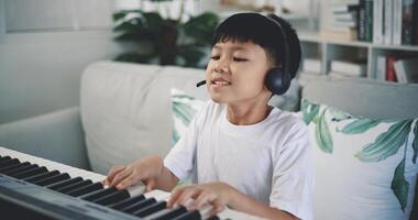 carino ragazzo godere per apprendimento giocando pianoforte a casa foto