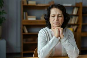 triste stanco malato malato solitario deluso più vecchio anziano donna seduta a casa solo. infelice maturo nonna sperimentare dolore parente Morte cattivo notizia. stressato Sambuco signora sofferenza a partire dal solitudine. foto