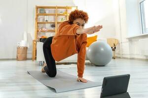 fitness allenarsi addestramento. giovane salutare in forma africano ragazza fare gli sport esercizio su yoga stuoia su pavimento a casa. atletico donna nel abbigliamento sportivo avere formazione allenarsi per peso perdita. sport e fitness. foto