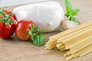 mozzarella biologica italiana con pomodorini e basilico su un tagliere foto