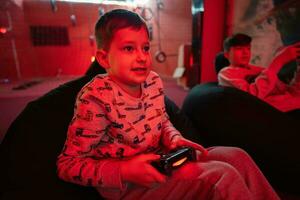 Due ragazzi giocatori giocare gamepad video gioco consolle nel rosso gioco camera. foto