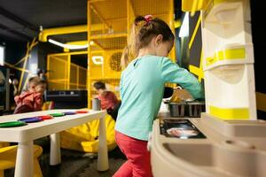 bambino ragazza giocando nel bambini cucina a bambini giocare centro. foto