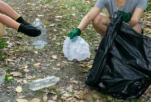 umano mano raccogliere plastica rifiuto nel spazzatura borse per il ambiente foto