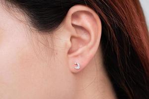 orecchino di diamante sull'orecchio di una donna asiatica foto
