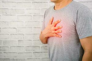 il uomo Tenere il il petto su il cuore cuore malattia sintomi foto