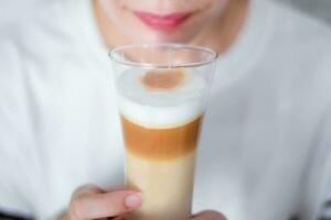 donna Tenere un' tazza caffè latte macchiato latte schiuma il caldo bevanda foto