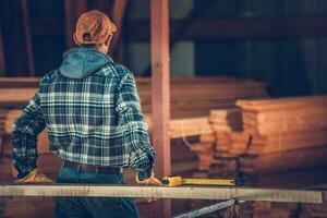 contraente falegname valutare a disposizione di legno Materiale nel magazzino. foto