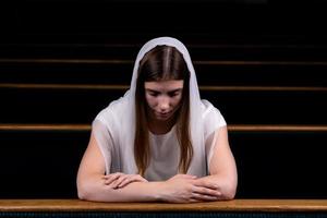 una ragazza cristiana che prega con cuore umile nella chiesa foto