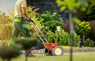 giardiniere con spingere spargitore fertilizzante Residenziale erba prato foto