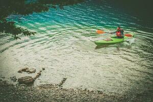 kayaker intestazione per il fiume riva foto