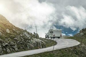 auto traino viaggio trailer su il panoramico alpino strada foto