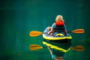 donna con sua cane nel kayak durante estate giorno foto