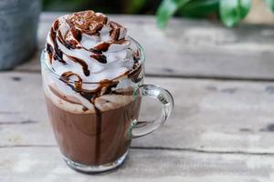 cioccolata calda cacao in tazza di vetro con panna montata foto