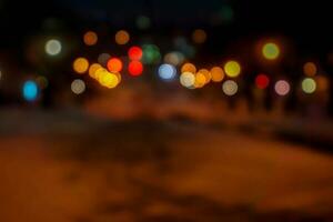 lungo tiro con sfocato e bokeh riflessione illuminazione di macchine testa luci su il strada con traffico su notte tempo città. foto