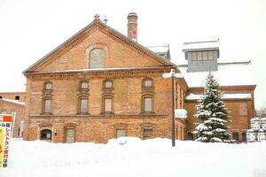 supporto, hokkaido, Giappone 2018- avvicinamento arancia mattone edificio di suppolo birra fabbrica con mucchio e di spessore neve paesaggio. foto