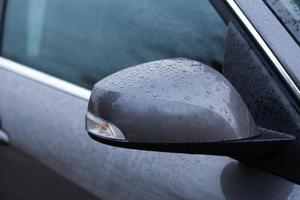 specchietto retrovisore dell'auto bagnato da gocce d'acqua foto