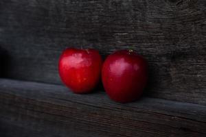 paio di mele rosse sulla tavola di legno con lo spazio della copia per testo foto