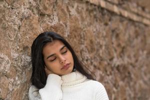 dolore al collo o rigidità giovane donna bruna chiudendo gli occhi massaggiandosi il collo sofferente foto