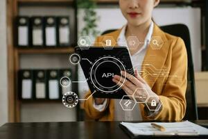 api applicazione programmazione interfaccia, donna utilizzando computer portatile, tavoletta e smartphone con virtuale schermo api icona Software sviluppo attrezzo, moderno tecnologia concetto. foto