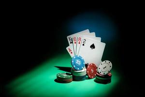 carte da poker e fiches in un fascio di luce su uno sfondo scuro con spazio di copia