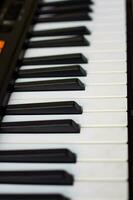 avvicinamento di pianoforte chiavi. pianoforte nero e bianca chiavi e pianoforte tastiera musicale strumento posto a il casa balcone durante soleggiato giorno. foto