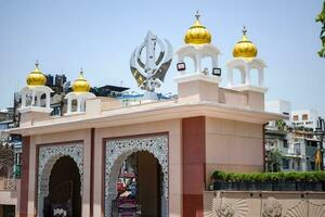 khanda sikh santo religioso simbolo a gurudwara Ingresso con luminosa blu cielo Immagine è prese a sorella ganj sahib gurudwara nel canni masticare, di fronte rosso forte nel vecchio delhi India foto