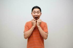 asiatico uomo arancia camicia si sente eccitato scioccato viso isolato foto