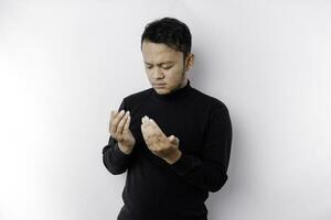 religioso asiatico uomo indossare un' nero camicia preghiere per Dio, isolato di un' bianca sfondo foto
