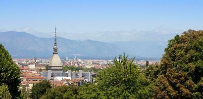 torino - Italia - urbano orizzonte con Talpa antonelliana costruzione, blu cielo e Alpi montagne. foto