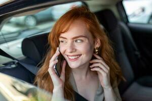 giovane ragazza usi un' mobile Telefono nel il macchina. tecnologia cellula Telefono isolamento. Internet e sociale media. donna con smartphone nel sua macchina. ragazza è utilizzando un' smartphone nel auto foto