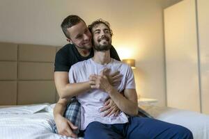 gay coppia Abbracciare una persona ogni altro con loro occhi Chiuso. Due giovane maschio Gli amanti toccante loro facce insieme mentre nel letto nel il mattina. affettuoso giovane gay coppia bonding a casa. foto