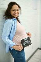 contento incinta donna Tenere ultrasuono scansione di sua bambino. gravidanza. ostetricia e ginecologia concetto. Salute cura foto