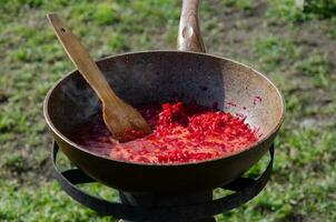 cucinando nel il cortile durante difficile volte. un' frittura padella nel quale condimento per borscht è preparato su il stufa nel il cortile.. foto