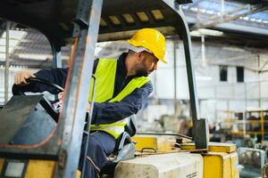 lavoratore indossare casco con guida carrello elevatore a forca indietro nel magazzino foto