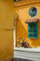 bicicletta parcheggiata a un' colorato angolo di il bellissimo coloniale strade a il murato città di cartagena de indie nel Colombia foto