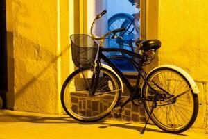 bicicletta parcheggiata a notte sotto un strada leggero su il bellissimo coloniale strade di il murato città di cartagena de indie nel Colombia foto