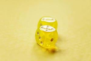 una macro monocromatica vibrante con profondità di campo su due dadi da gioco di vetro giallo foto