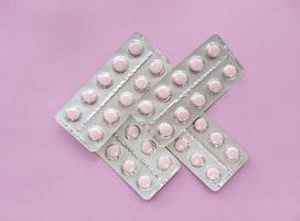 blister di morbide pillole rosa su sfondo rosa monocromatico piatto semplice laici con texture pastello concetto medico stock foto