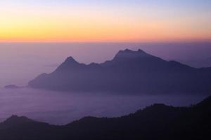 mare di nebbia e silhouette di montagna con l'alba al mattino a phu chi fa chiangrai thailandia