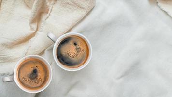 vista dall'alto della tazza di caffè su una tovaglia bianca foto