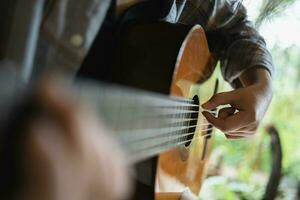 contento giovane donna mani giocando acustico chitarra musicista foto