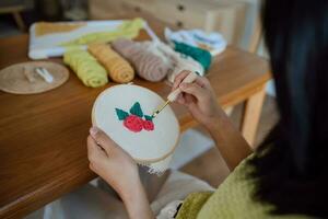 punch ago. asiatico donna fabbricazione fatto a mano passatempo maglieria nel studio officina. progettista posto di lavoro fatto a mano mestiere progetto Fai da te ricamo concetto. foto