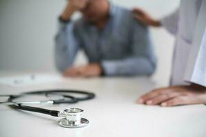 medico assistenza sanitaria. professionale medico medico nel bianca uniforme toga cappotto colloquio consulenza paziente rassicurante il suo maschio paziente porzione mano foto