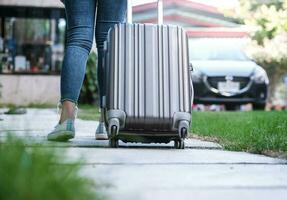 viaggiatore donna trasporto bagaglio. turista a piedi con valigie viaggio stile di vita concetto. foto